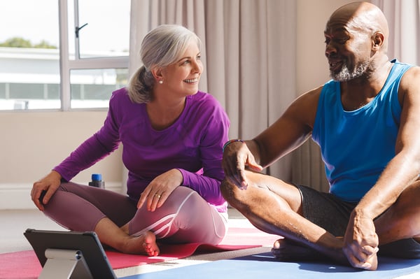 happy-senior-diverse-couple-practicing-yoga-talking